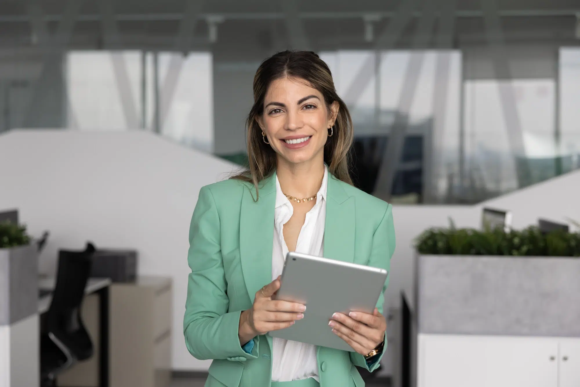 Woman holding a tablet in an office while learning how Fast Loan Advance works and exploring loan options